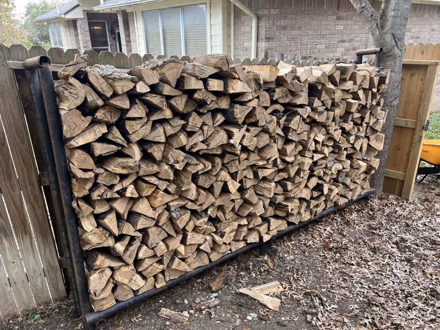 Seasoned split oak firewood stacked full in a steel rack